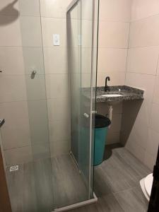 uma casa de banho com um chuveiro, um lavatório e um balde em casa lucena 1 em Lucena