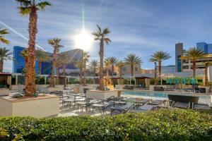 ein Resort mit einem Pool, Palmen und Stühlen in der Unterkunft MGM Signature-36-603 Strip View Jacuzzi Studio in Las Vegas