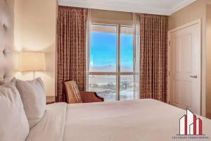 een slaapkamer met een groot bed en een groot raam bij MGM Signature-28-714 1BR 2-Bath Balcony Suite in Las Vegas +72 foto's