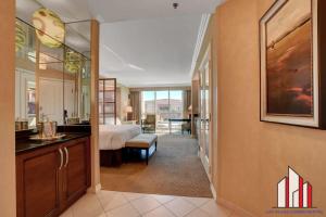 a hotel room with a bedroom and a bed and a desk at MGM Signature-02-604 Jacuzzi Studio in Las Vegas