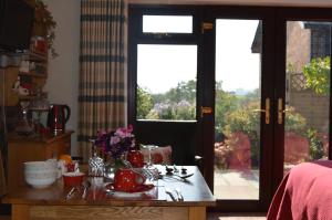 a room with a table with tea pots and flowers on it at Smithfield Farm Bed & Breakfast in Builth Wells