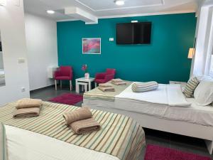 Cette chambre comprend 3 lits et une télévision murale. dans l'établissement Flamingo Resort, à Belgrade
