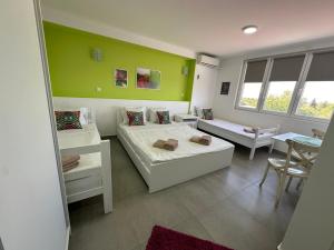 een kamer met 2 bedden en een tafel en stoelen bij Flamingo Resort in Belgrado
