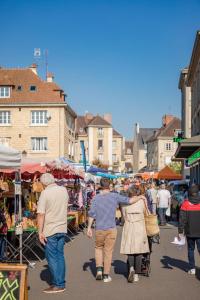 un grupo de personas caminando por un mercado al aire libre en Cœur de Falaise, Normandie Suisse Normande en Falaise
