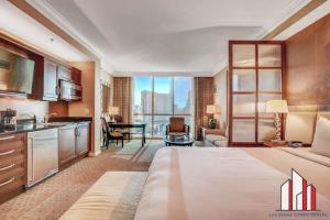 um quarto de hotel com uma cama grande e uma cozinha em MGM Signature-17-703 Strip View Jacuzzi Studio em Las Vegas mais 37 fotografias