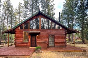 a cabin in the woods with a wooden deck at Cascade Cabin in Sunriver