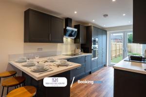 a kitchen with blue cabinets and a kitchen island with stools at 2 Bedroom, Brand new property By Broad Meadow Stays Short Lets and Serviced Accommodation Lincoln With Garden in Lincoln