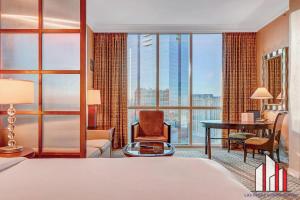 een hotelkamer met een bed en een groot raam bij MGM Signature-30-719 Strip View Jacuzzi Studio in Las Vegas +44 foto's