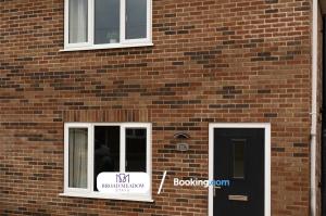 a brick building with a door and a sign on it at 2 Bedroom, Brand new property By Broad Meadow Stays Short Lets and Serviced Accommodation Lincoln With Garden in Lincoln