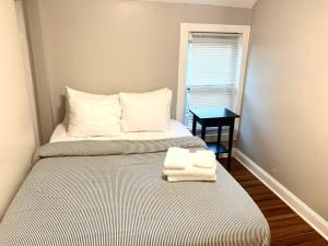 a bedroom with two towels on a bed with a window at The House Hotels - W45th Backhouse - Ohio City District Home - 5 Minutes from Downtown in Cleveland