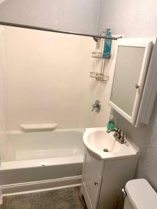 a white bathroom with a sink and a bath tub at The House Hotels - W45th Backhouse - Ohio City District Home - 5 Minutes from Downtown in Cleveland