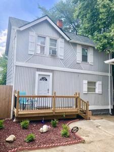 a house with a porch with a bench in front of it at The House Hotels - W45th Backhouse - Ohio City District Home - 5 Minutes from Downtown in Cleveland