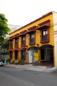 een geel gebouw met balkons in een stadsstraat bij Hotel Doña Alicia in Oaxaca City