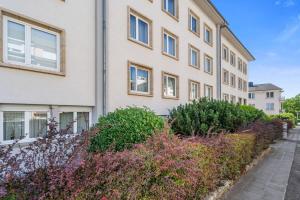 un edificio de apartamentos con flores delante en Tranquil Retreat in the Vianden ID224, en Luxemburgo