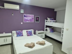 um quarto com 2 camas e uma parede roxa em Flamingo Resort em Belgrado