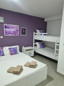 um quarto com 2 camas e uma parede roxa em Flamingo Resort em Belgrado