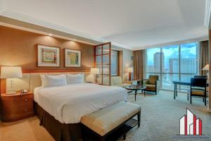 a hotel room with a large bed and a desk at MGM Signature-24-709 Strip View Jacuzzi Studio in Las Vegas