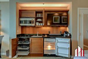 a kitchen with stainless steel appliances and wooden cabinets at MGM Signature-24-709 Strip View Jacuzzi Studio in Las Vegas