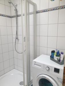 a washing machine in a bathroom with a shower at Erholung Pur bei Nina in Bad Lauterberg