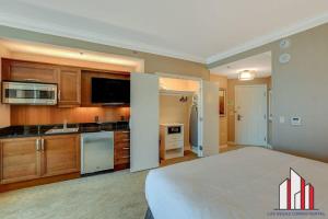 a large bedroom with a large bed and a kitchen at MGM Signature-24-709 Strip View Jacuzzi Studio in Las Vegas