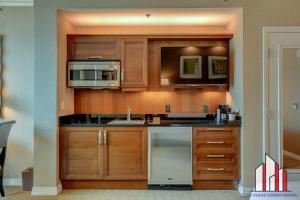 a kitchen with wooden cabinets and stainless steel appliances at MGM Signature-24-709 Strip View Jacuzzi Studio in Las Vegas
