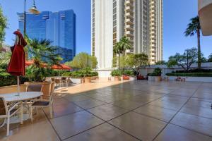 a patio with tables and chairs and tall buildings at MGM Signature-24-709 Strip View Jacuzzi Studio in Las Vegas