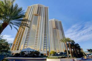 a large building with palm trees in front of it at MGM Signature-24-709 Strip View Jacuzzi Studio in Las Vegas