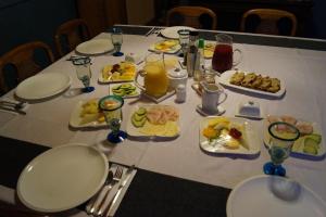 una mesa con platos de comida y bebidas. en Tradicion Austral Bed & Breakfast en Puerto Varas