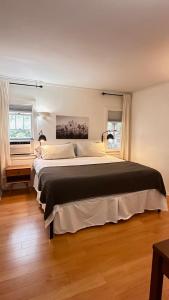 - un grand lit dans une chambre avec 2 fenêtres dans l'établissement Echo Park Hills, à Los Angeles