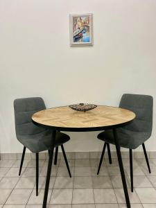 a wooden table with two chairs and a picture on the wall at Adria in Portorož