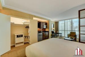 um quarto de hotel com uma cama grande e uma cozinha em MGM Signature-22-611 Strip View Jacuzzi Studio em Las Vegas