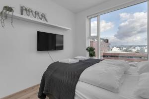 a bedroom with a large bed with a flat screen tv at Spacious Luxury 3BR Apartment with 2 bathrooms 1003 in Reykjavík