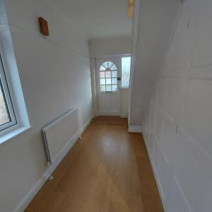 an empty hallway with a door and a window at Jemima Place semi-detached hse. in Wallington