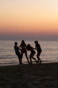 um grupo de pessoas brincando na praia ao pôr do sol em Romantic Private Cabin em Estepona