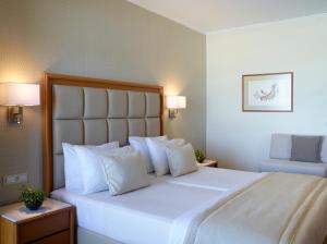 a bedroom with a large white bed with white pillows at Apollo Beach in Faliraki