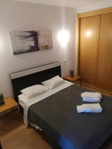 a bedroom with a bed with two towels on it at Rocha T Apartments in Portimão +56 photos