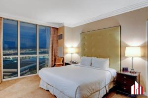 ein Hotelzimmer mit einem großen Bett und einem großen Fenster in der Unterkunft MGM Signature-20-620 1Br 2Ba Balcony Suite in Las Vegas