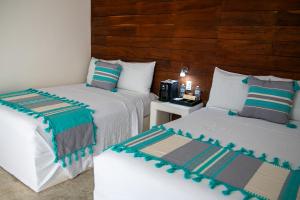 um quarto com 2 camas e uma mesa com uma cama em Hotel Boutique Villa Balu em Bacalar