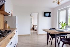 a kitchen with a table and a kitchen with white appliances at Pokoje i Apartamenty Marek - Niedaleko Plaży in Ostrowo