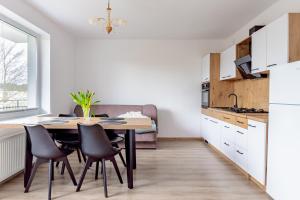 a kitchen and dining room with a table and chairs at Pokoje i Apartamenty Marek - Niedaleko Plaży in Ostrowo