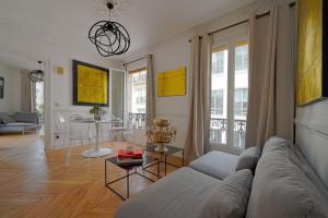 een woonkamer met een bank en een tafel bij Large Luxury flat next to Champs Elysée in Parijs