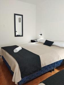 a bedroom with two beds and a mirror on the wall at Habitaciones cerca al aeropuerto centro y centro conecta embajada americana in Bogotá