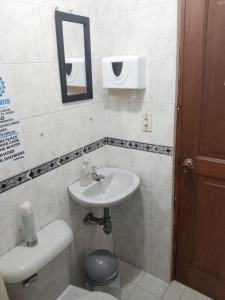 a bathroom with a sink and a toilet and a mirror at Habitaciones cerca al aeropuerto centro y centro conecta embajada americana in Bogotá
