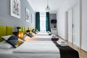 una fila de camas alineadas en una habitación en Friendhouse Apartments Starovislna, en Cracovia