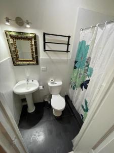 a bathroom with a toilet and a sink and a mirror at Illa B&B in Cusco