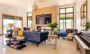 a living room with a couch and a piano at Superbe Villa avec piscine intérieure chauffée in Bonneville-sur-Touques