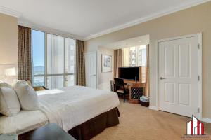 a bedroom with a large bed and a desk with a television at MGM Signature-31-702 1Bedroom 2Bath Balcony Suite in Las Vegas