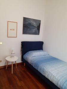 een slaapkamer met een blauw bed en een kleine tafel bij Casa vacanze La Madonnetta in Arcade