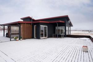 a black house with a pavilion on top of a lot at The Golden Circle Lodge - Luxurious villa with Jacuzzi and Sauna in Þingvellir