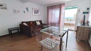 a living room with a couch and a glass table at Vv Apartamento Gran Vista Los Marinos in Tías